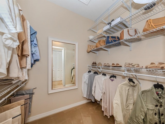 walk in closet with light colored carpet