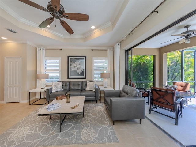 living room featuring crown molding, ceiling fan, and a raised ceiling