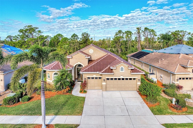 mediterranean / spanish home with a garage and a front lawn