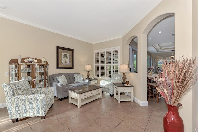 living room with ornamental molding, tile patterned floors, and a raised ceiling