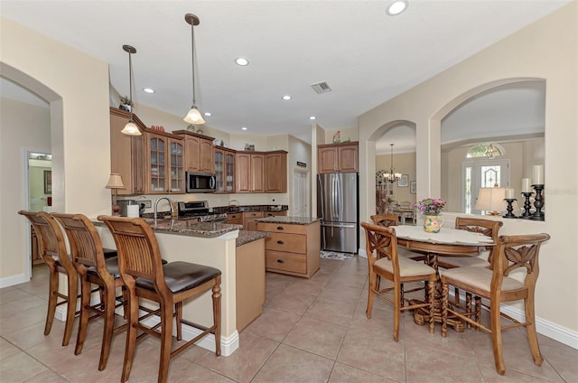 kitchen featuring light tile patterned flooring, stainless steel appliances, and kitchen peninsula