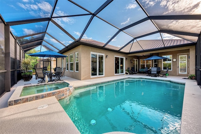 view of swimming pool with a patio, an in ground hot tub, and a lanai