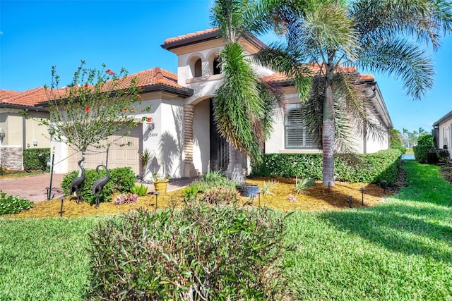 mediterranean / spanish home featuring a garage and a front lawn