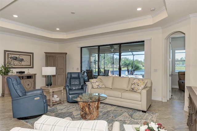 tiled living room featuring a tray ceiling and ornamental molding