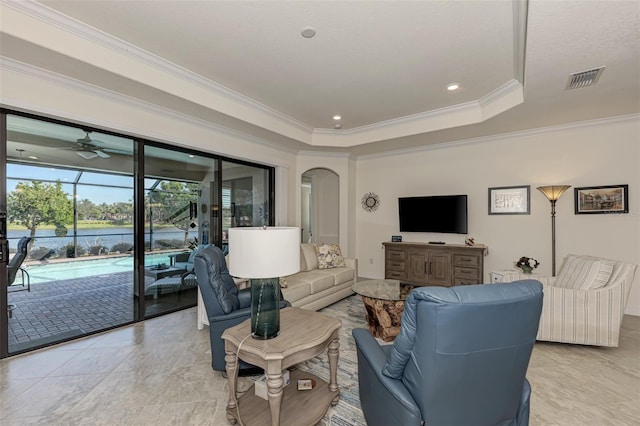 living room featuring ornamental molding, ceiling fan, light tile floors, and a tray ceiling