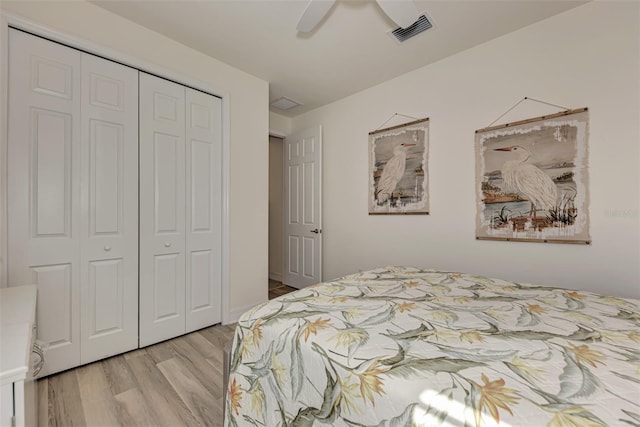 bedroom with a closet, light hardwood / wood-style floors, and ceiling fan