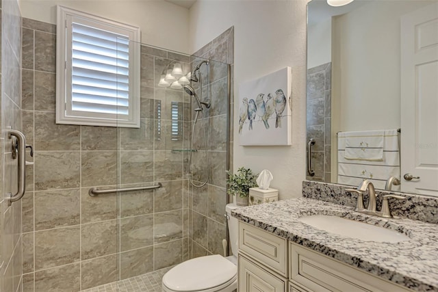 bathroom featuring an enclosed shower, toilet, and large vanity