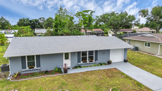 ranch-style home with a garage, a front lawn, and central AC unit