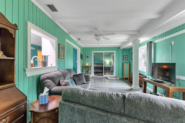 living room featuring beam ceiling, ceiling fan, hardwood / wood-style flooring, and decorative columns