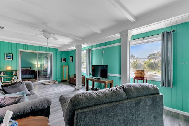 living room with hardwood / wood-style flooring, ceiling fan, beamed ceiling, and decorative columns