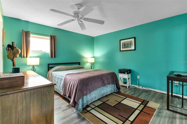 bedroom with wood-type flooring, ceiling fan, and a textured ceiling