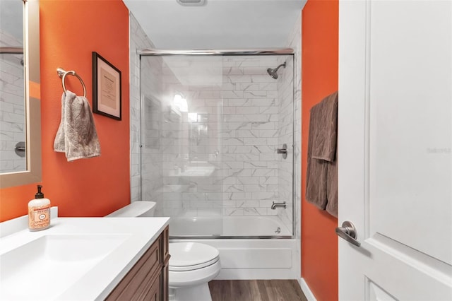 full bathroom featuring toilet, shower / bath combination with glass door, vanity, and hardwood / wood-style floors