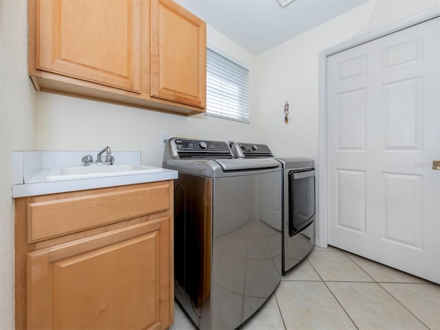 clothes washing area with cabinets, independent washer and dryer, light tile patterned flooring, and sink