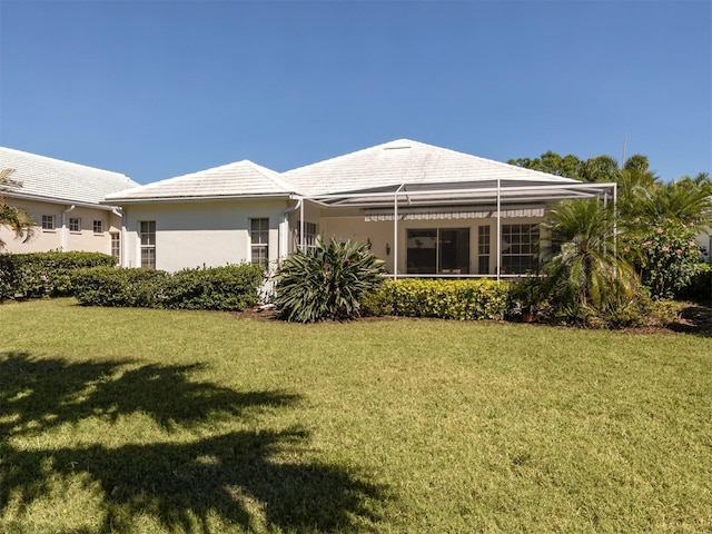 rear view of property featuring a lawn