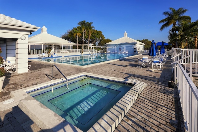 view of pool featuring a hot tub and a patio area