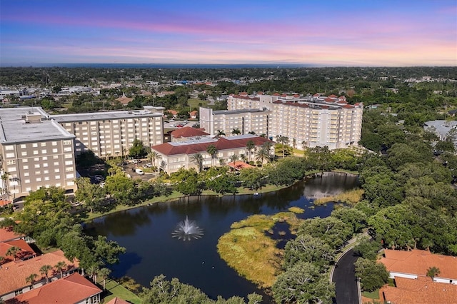 aerial view at dusk featuring a water view