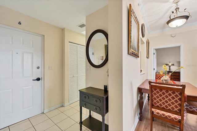 corridor with ornamental molding and light tile floors