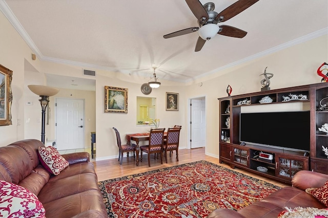 living room with hardwood / wood-style flooring, crown molding, and ceiling fan