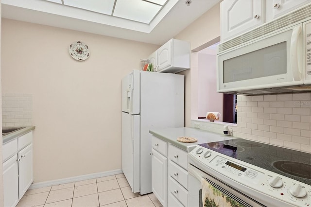 kitchen featuring backsplash, white appliances, light tile flooring, and white cabinetry