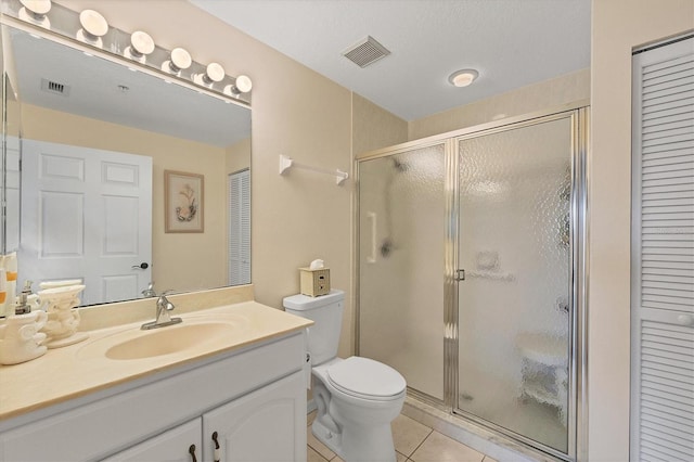 bathroom featuring a shower with door, toilet, tile flooring, and vanity