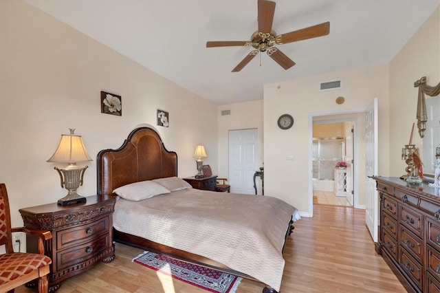 bedroom with light hardwood / wood-style flooring, connected bathroom, ceiling fan, and a closet