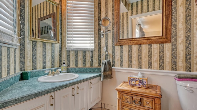 bathroom with vanity with extensive cabinet space and toilet