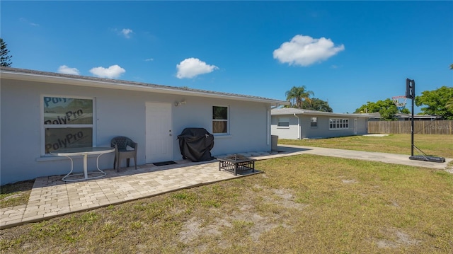 back of property with a yard and a patio area