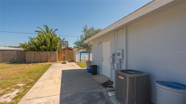 view of property exterior with central AC, a yard, a patio, and a storage unit