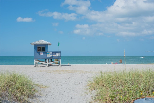 view of dock with a beach view and a water view