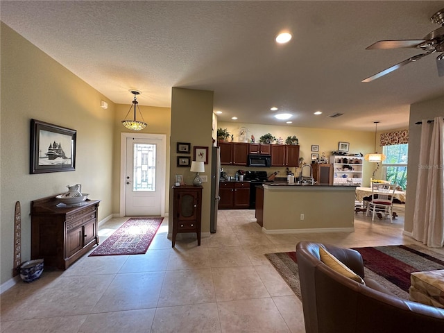 living room featuring sink, a textured ceiling, ceiling fan, and light tile floors