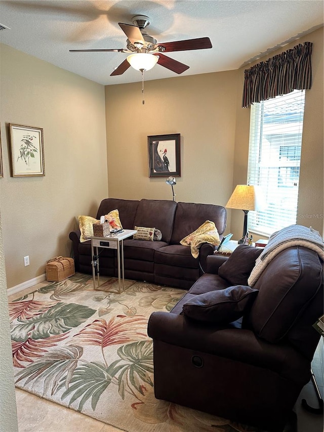 living room featuring light colored carpet, ceiling fan, and a textured ceiling