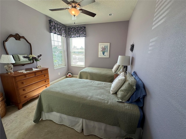 bedroom with ceiling fan and a textured ceiling