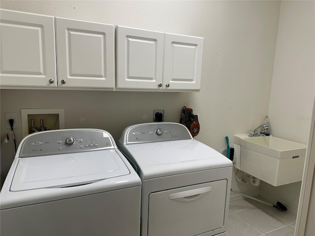 laundry room with hookup for an electric dryer, separate washer and dryer, sink, light tile floors, and cabinets