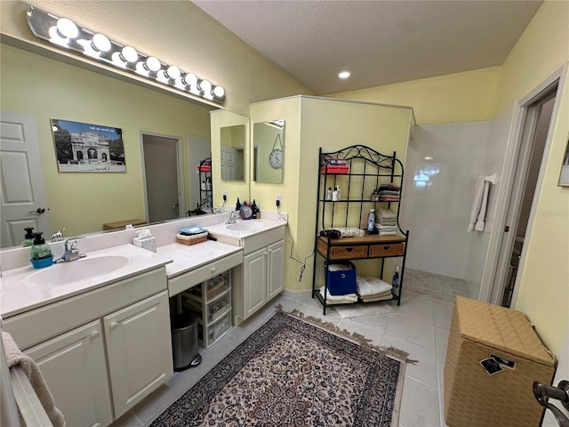 bathroom with double sink vanity, a textured ceiling, and tile flooring