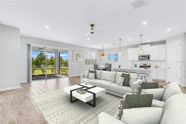 living room featuring ceiling fan with notable chandelier