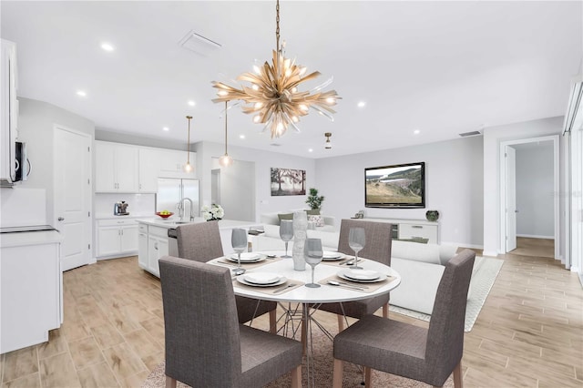 dining space featuring sink and an inviting chandelier