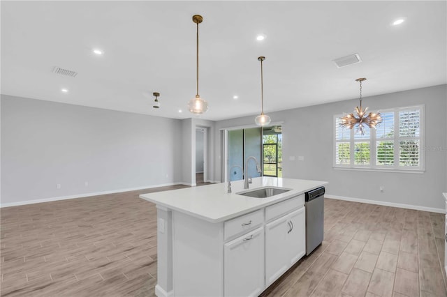 kitchen featuring white cabinets, sink, dishwasher, hanging light fixtures, and an island with sink