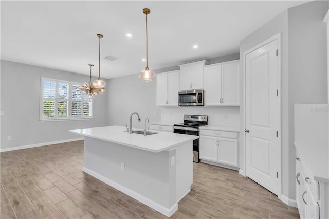 kitchen featuring white cabinetry, a kitchen island with sink, sink, and stainless steel appliances