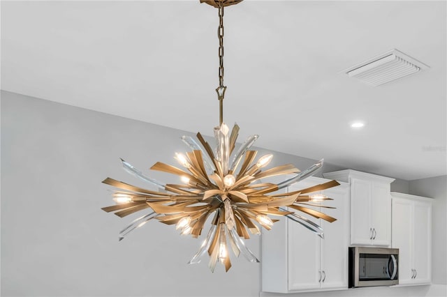 interior details featuring white cabinetry and a notable chandelier