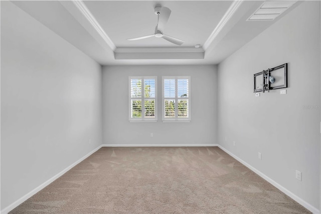 unfurnished room with carpet floors, a raised ceiling, ceiling fan, and ornamental molding