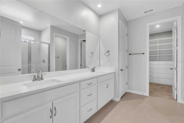 bathroom featuring tile patterned flooring, vanity, and a shower with shower door