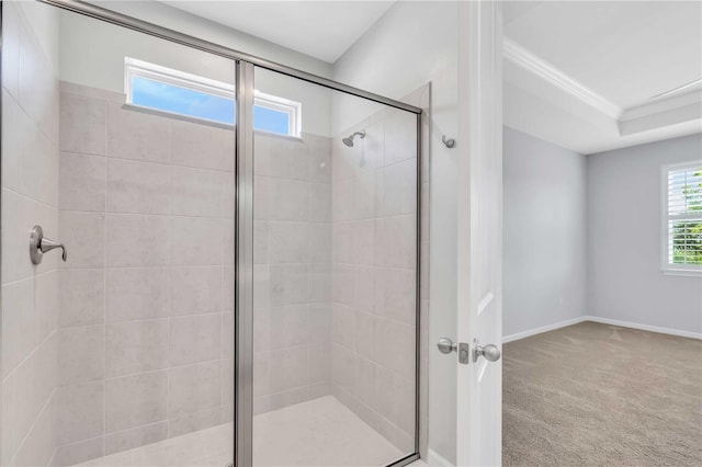 bathroom with a raised ceiling, crown molding, and a shower with shower door