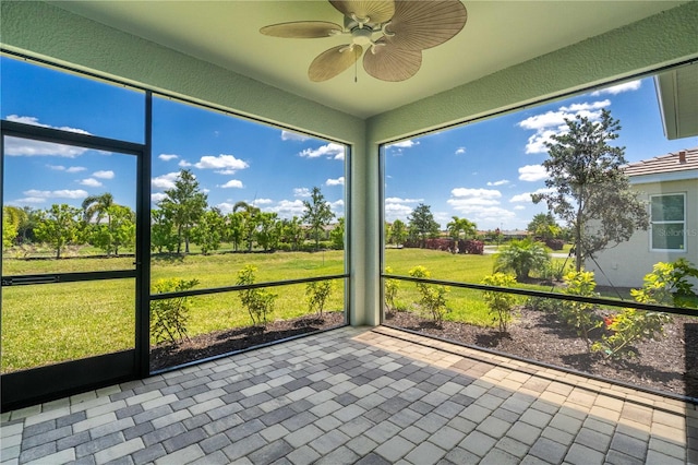 unfurnished sunroom with ceiling fan