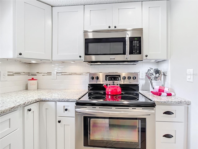 kitchen with tasteful backsplash, stainless steel appliances, and white cabinetry