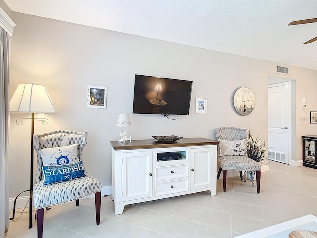 sitting room featuring ceiling fan and light tile flooring