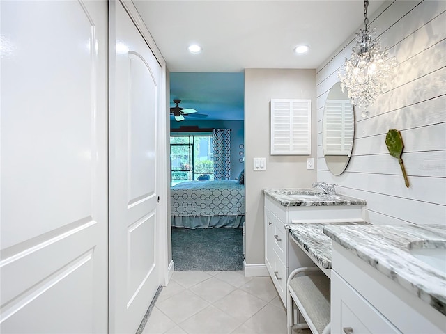 bathroom with ceiling fan with notable chandelier, tile flooring, and vanity