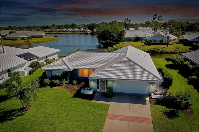 aerial view at dusk featuring a water view