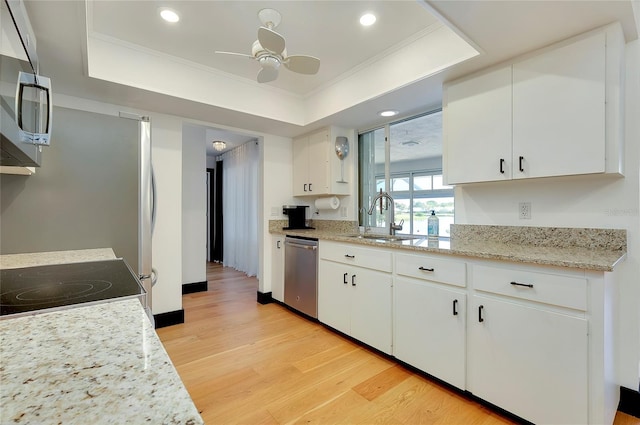 kitchen featuring white cabinetry, sink, stainless steel appliances, and a raised ceiling