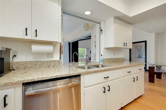 kitchen featuring sink, white cabinets, stainless steel dishwasher, light stone counters, and light wood-type flooring