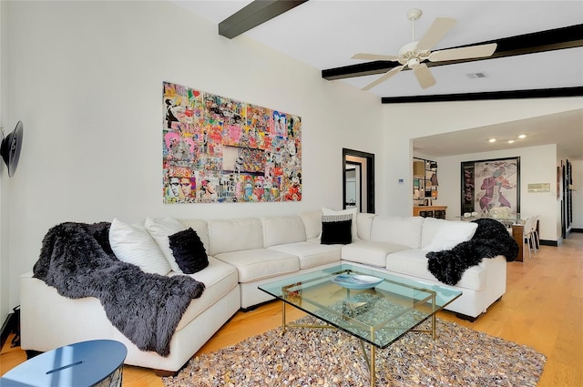 living room featuring vaulted ceiling with beams, ceiling fan, and light wood-type flooring